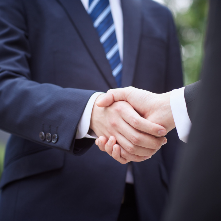 box-id_partner Das Bild zeigt zwei Menschen die sich die Hand geben.